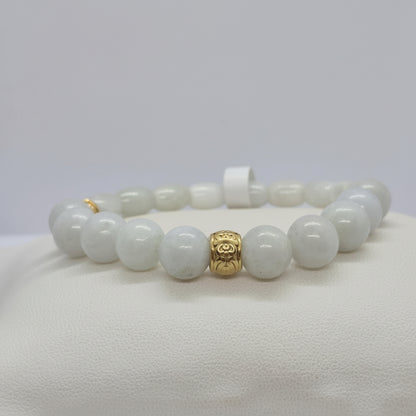 Bracelet with white burmese jade beads and a gold charm on a white background