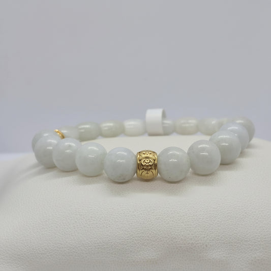 Bracelet with white burmese jade beads and a gold charm on a white background